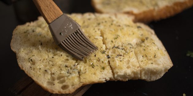 Как приготовить чесночные гренки с сыром: распределите масло по всей поверхности хлеб