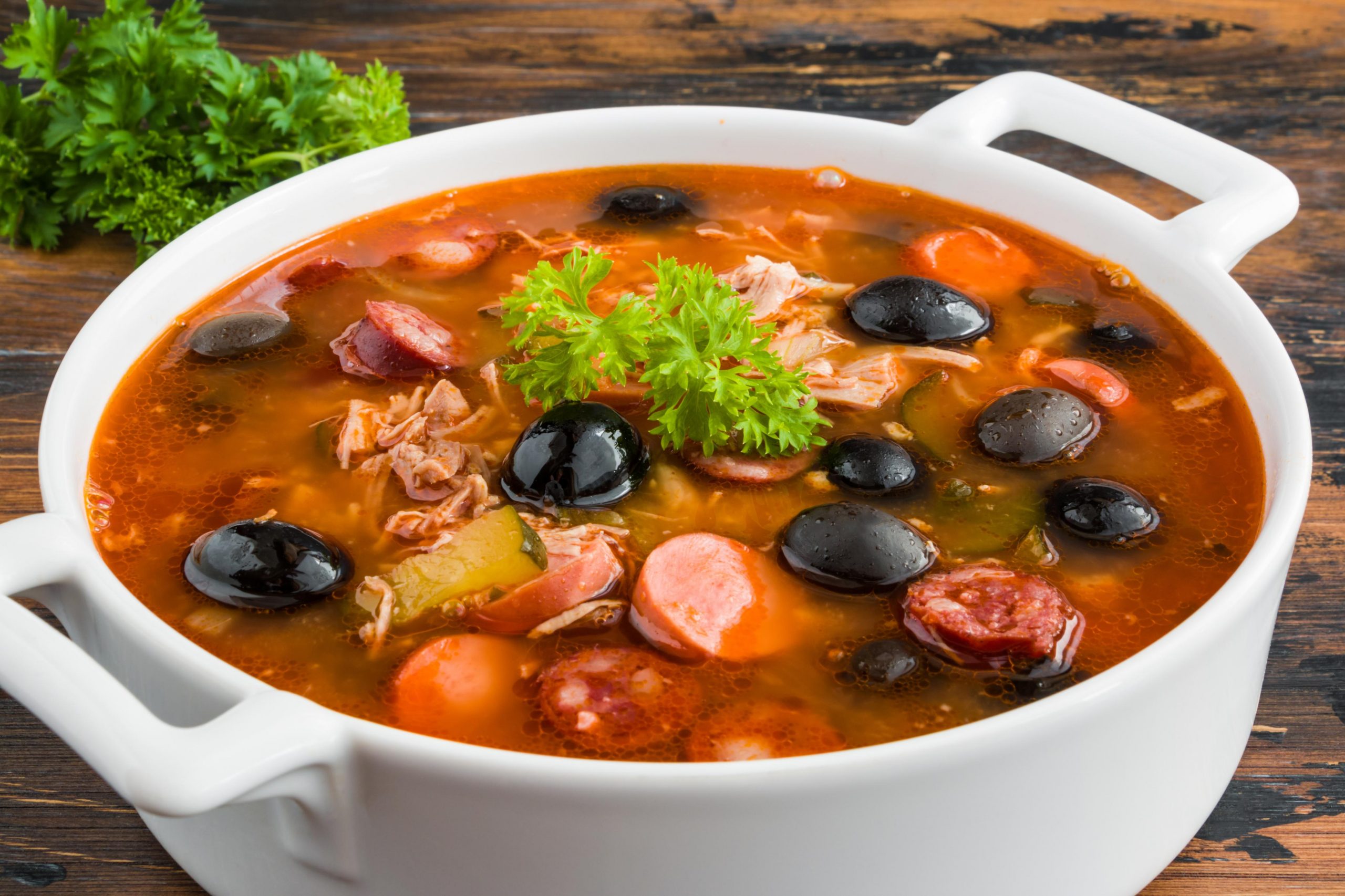Тарелка солянки с лимоном и оливками